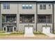 Rear view of townhouse with balconies, garage doors, and neutral-toned siding at 408 Old Town Village Rd, Waxhaw, NC 28173