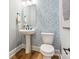 Stylish powder room featuring geometric wallpaper, pedestal sink and modern fixtures at 408 Old Town Village Rd, Waxhaw, NC 28173