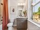 Bright bathroom with a window over looking the yard, and a shower with orange curtain at 408 Old Town Village Rd, Waxhaw, NC 28173