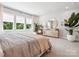 Sunlit bedroom featuring large windows with leafy backyard views at 408 Old Town Village Rd, Waxhaw, NC 28173