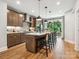 Modern kitchen with a large island, stainless steel appliances, and a door to the outdoor balcony overlooking a wooded area at 408 Old Town Village Rd, Waxhaw, NC 28173
