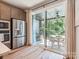Bright kitchen with stainless steel appliances leading to an outdoor patio with a round table at 408 Old Town Village Rd, Waxhaw, NC 28173