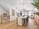 Open-concept living and dining area with hardwood floors, modern lighting, staircase, and comfortable seating, perfect for gathering at 408 Old Town Village Rd, Waxhaw, NC 28173