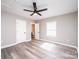 Well-lit bedroom with wood-look floors, a modern fan, and neutral walls at 4221 E Maiden Rd, Maiden, NC 28650