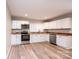 Bright kitchen features white cabinets, stainless steel appliances, and hardwood floors at 4221 E Maiden Rd, Maiden, NC 28650