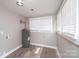 Well-lit utility room featuring modern water heater, updated flooring, and double windows at 4221 E Maiden Rd, Maiden, NC 28650