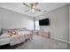 Cozy bedroom with neutral walls and carpet, featuring a ceiling fan and television at 4631 Christina Ct, Gastonia, NC 28056
