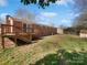 A view of the backyard, featuring a wooden deck and spacious lawn area for outdoor activities at 5012 Maplecrest Dr, Gastonia, NC 28056