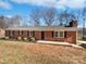 Quaint brick ranch home with manicured shrubbery and a walkway leading to the front door at 5012 Maplecrest Dr, Gastonia, NC 28056