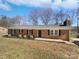 Charming brick home with a well-maintained lawn and dark shutters on a sunny day at 5012 Maplecrest Dr, Gastonia, NC 28056