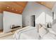 Bright bedroom showcasing a sloped wood ceiling, paneled accent wall, and minimalist design elements at 5500 Carmel Rd # 101, Charlotte, NC 28226