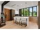Modern kitchen with sleek white island, counter seating, stylish lighting, and expansive windows for a bright, inviting space at 5500 Carmel Rd # 101, Charlotte, NC 28226