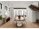 Open dining room with modern lighting, contemporary furniture, and stairway to the second floor at 5500 Carmel Rd # 103, Charlotte, NC 28226