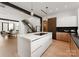 Modern kitchen featuring a large island, wood floors and an open concept layout to the dining and stairs at 5500 Carmel Rd # 103, Charlotte, NC 28226