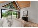 Bedroom featuring large windows, vaulted wood ceilings, backyard view, and contemporary design at 5500 Carmel Rd # 103, Charlotte, NC 28226