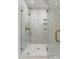 Elegant marble shower with frameless glass enclosure and contemporary gold fixtures at 5500 Carmel Rd # 103, Charlotte, NC 28226