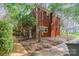 Brick home exterior with mature trees, fenced yard, and a concrete patio, offering privacy and outdoor space at 5536 Seacroft Rd, Charlotte, NC 28210