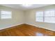 Bedroom featuring hardwood floors, two windows, and base trim at 5536 Seacroft Rd, Charlotte, NC 28210
