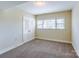 Bright bedroom with plush carpet, a large window, and a double-door closet at 5536 Seacroft Rd, Charlotte, NC 28210