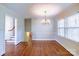 Bright dining area with hardwood floors and a classic chandelier, adjacent to a staircase leading upstairs at 5536 Seacroft Rd, Charlotte, NC 28210