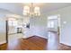 Open-concept dining area leading into the kitchen, featuring hardwood floors, stainless steel appliances, and modern lighting at 5536 Seacroft Rd, Charlotte, NC 28210