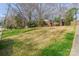 Wide shot of a brick home set atop a gently sloping lawn with mature trees and shrubs adding to its natural beauty at 5536 Seacroft Rd, Charlotte, NC 28210