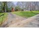 View of a well-maintained brick home from driveway, showcasing curb appeal with mature trees and landscaping at 5536 Seacroft Rd, Charlotte, NC 28210