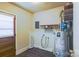 Utility room featuring a water heater, shelving and connections for a washing machine and dryer at 5536 Seacroft Rd, Charlotte, NC 28210