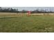 Vast grassy yard with a red barn and fencing, great for outdoor activities or agricultural pursuits at 6795 Jones Rd, Salisbury, NC 28147