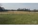 Expansive open grassy field surrounded by trees and foliage, perfect for outdoor activities or enjoying nature at 6795 Jones Rd, Salisbury, NC 28147