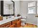Bright bathroom featuring wood floors, wood vanity, and tub/shower combo at 7331 Sedgebrook W Dr, Stanley, NC 28164