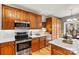 Well-equipped kitchen boasts stainless steel appliances, natural wood cabinets, and bright white countertops at 7331 Sedgebrook W Dr, Stanley, NC 28164