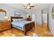 Comfortable primary bedroom with wood floors, ceiling fan, and ensuite access at 7331 Sedgebrook W Dr, Stanley, NC 28164