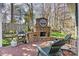Outdoor patio featuring a stone fireplace, grilling station and Adirondack chairs at 7331 Sedgebrook W Dr, Stanley, NC 28164