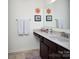 Modern bathroom with a granite countertop, dark cabinets, and decorative accents above the sink and towel racks at 7456 Hartsfield Dr, Lancaster, SC 29720