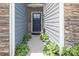 Inviting front entrance featuring a stylish door, stone accents, and lush landscaping at 7456 Hartsfield Dr, Lancaster, SC 29720