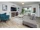 Comfortable living room features a plush sofa, accent chair, and a decorative cabinet with a large TV at 7456 Hartsfield Dr, Lancaster, SC 29720