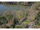 Expansive aerial view showcases a lakefront home nestled among mature trees, offering serene waterfront living at 7611 Buckland Rd, Charlotte, NC 28278