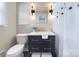 Stylish bathroom featuring a navy blue vanity with gold hardware, modern light fixtures, and updated fixtures at 7611 Buckland Rd, Charlotte, NC 28278