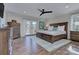 Spacious bedroom featuring hardwood floors, a ceiling fan, and balcony access through French doors at 7611 Buckland Rd, Charlotte, NC 28278
