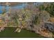 Picturesque lake view highlighting a waterfront property with a dock, accessible by a wooden walkway through mature trees at 7611 Buckland Rd, Charlotte, NC 28278
