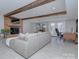 Cozy living area with exposed beam ceilings, fireplace, and lake view from the large glass doors at 7611 Buckland Rd, Charlotte, NC 28278
