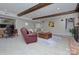 Spacious living room featuring wooden beams, a fireplace, and access to a staircase for versatile living at 7611 Buckland Rd, Charlotte, NC 28278