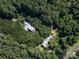 Aerial view of a secluded home nestled amongst dense green trees, offering privacy and tranquility at 7794 Live Oaks Dr, Denver, NC 28037