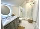 Modern bathroom boasts a glass shower, sleek vanity, and unique circular mirror at 7794 Live Oaks Dr, Denver, NC 28037
