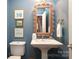 Powder room with a unique pedestal sink, woven mirror, and blue walls at 7794 Live Oaks Dr, Denver, NC 28037