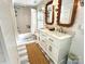 Bright bathroom featuring double sink vanity, decorative mirrors, tub with shower and blue and white tiling at 7794 Live Oaks Dr, Denver, NC 28037