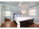 Bright bedroom with light blue walls, ceiling fan, wood floors and a window with lots of natural light at 7794 Live Oaks Dr, Denver, NC 28037