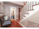Hallway with stairway, grandfather clock, and a glimpse into the powder room at 7794 Live Oaks Dr, Denver, NC 28037