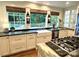 Bright kitchen with green countertops, farm sink, and stainless steel appliances, offering a functional and stylish space at 7794 Live Oaks Dr, Denver, NC 28037